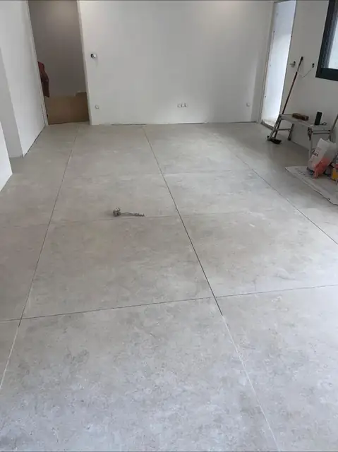 Pose de carrelage grand format dans une pièce à vivre